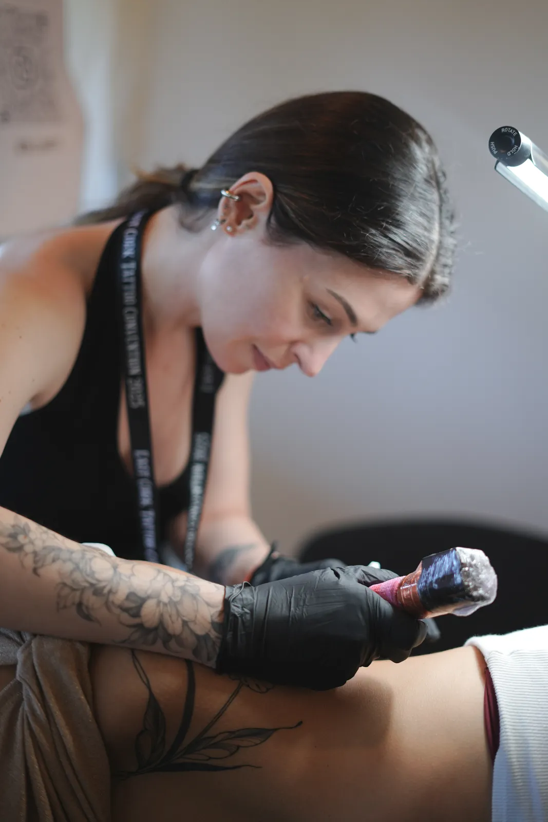 Talita desenhando &agrave; m&atilde;o livre no bra&ccedil;o de uma cliente