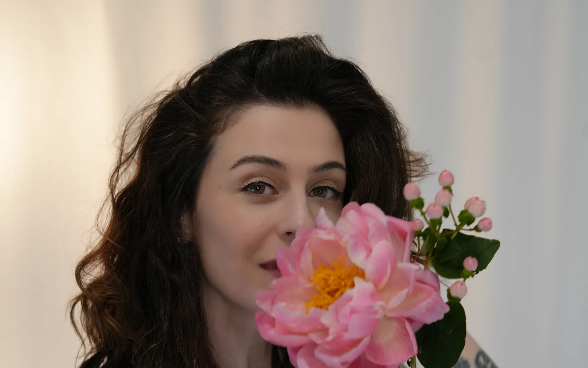 Retrato de Talita com uma pe&ocirc;nia rosa junto ao rosto