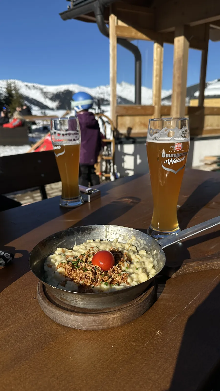 Sp&auml;tzle e cerveja de trigo num terra&ccedil;o na montanha