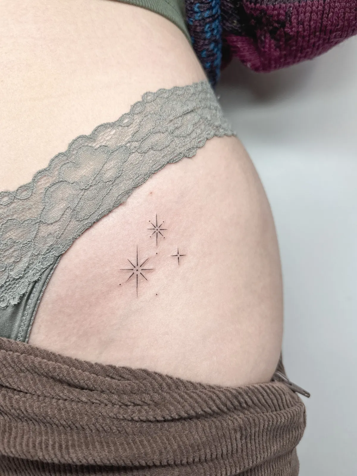 Tr&ecirc;s estrelas tatuadas no quadril