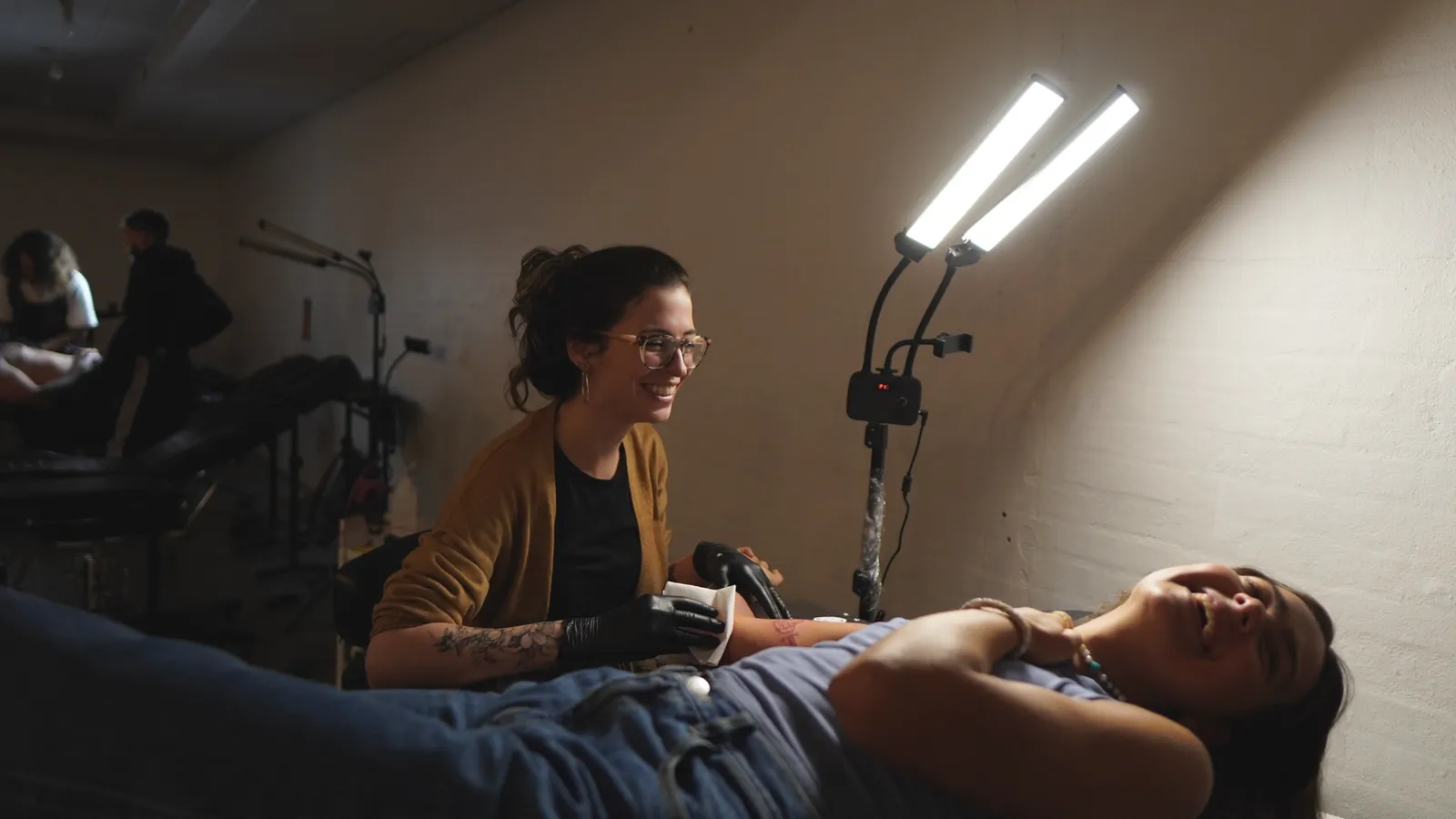 Talita sorrindo enquanto tatua no est&uacute;dio